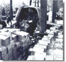 Nederlandse laden de vrachtwagens van de 49ste divisie uit.